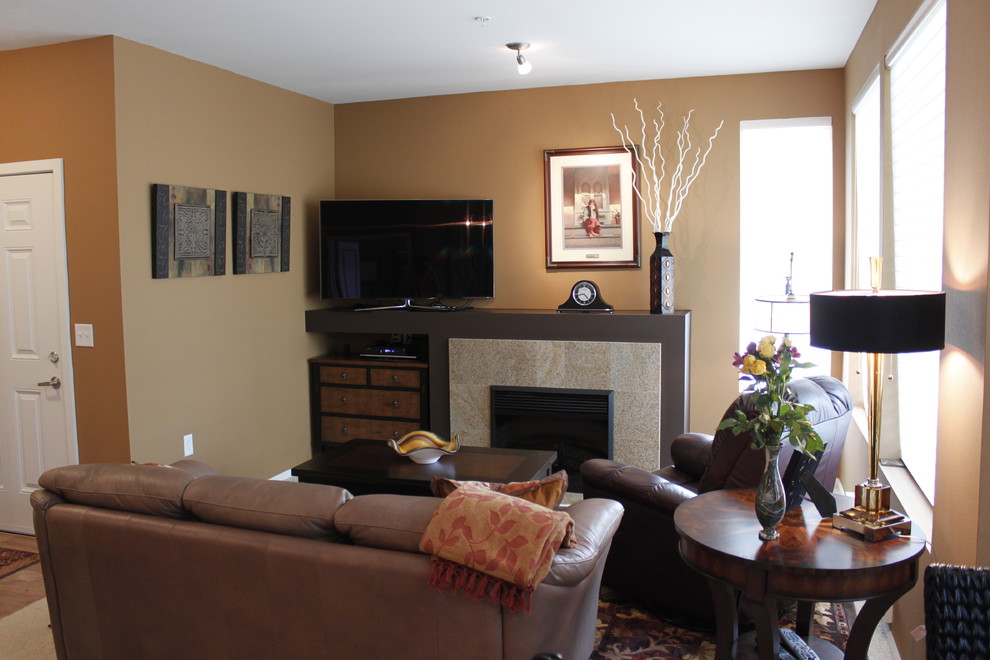 シアトルにある中くらいなコンテンポラリースタイルのおしゃれなLDK (茶色い壁、標準型暖炉、据え置き型テレビ、淡色無垢フローリング、タイルの暖炉まわり) の写真