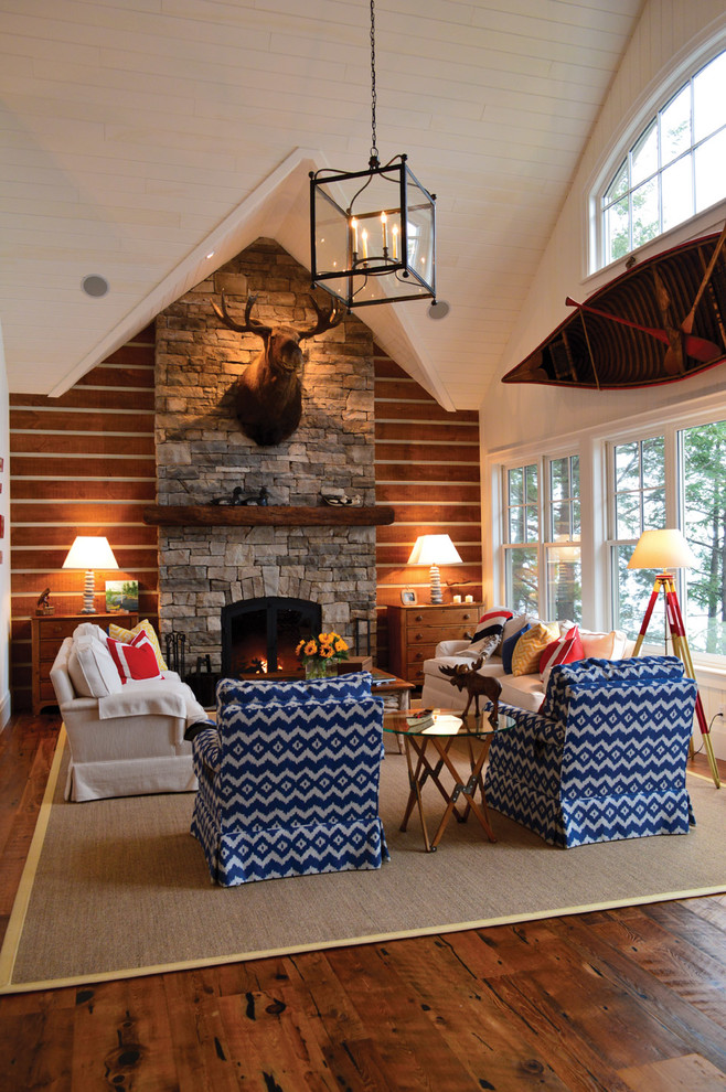 Cette photo montre un salon montagne avec une cheminée standard, un manteau de cheminée en pierre et éclairage.