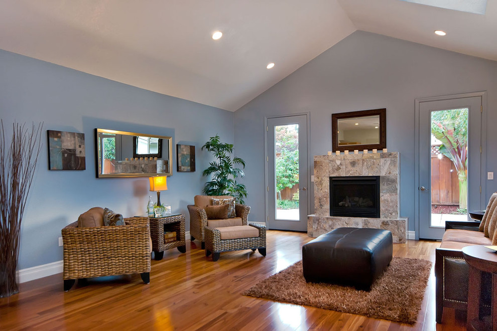 Стильный дизайн: гостиная комната в современном стиле с синими стенами, стандартным камином и фасадом камина из камня - последний тренд