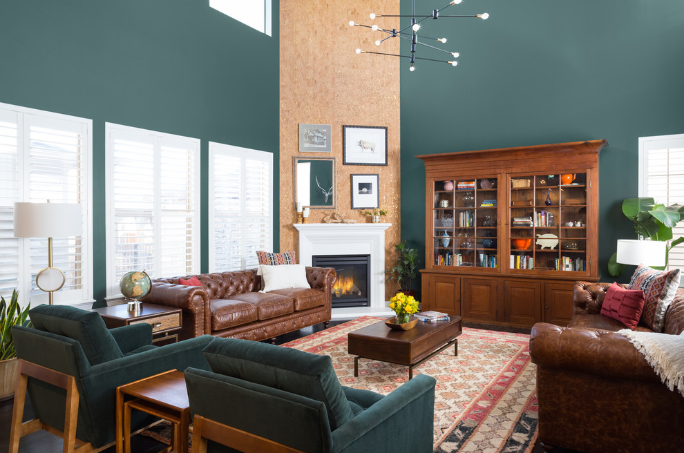 Cette image montre un grand salon vintage ouvert avec une salle de réception, un mur vert, parquet foncé, une cheminée d'angle, un manteau de cheminée en plâtre, aucun téléviseur et un sol marron.
