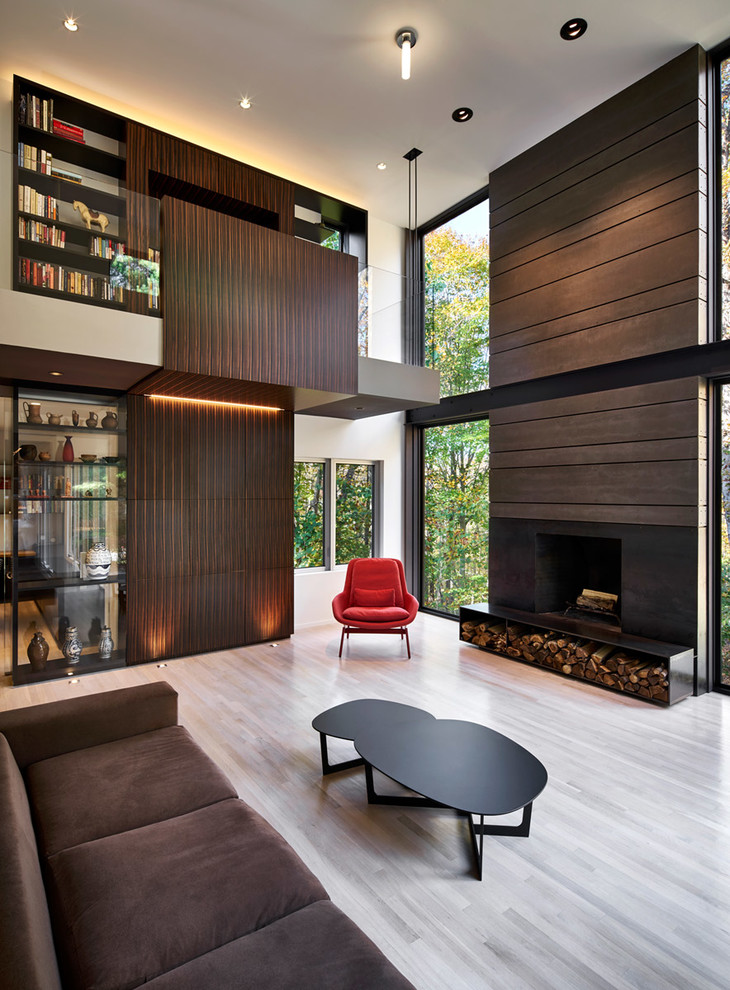 Стильный дизайн: гостиная комната в современном стиле с коричневыми стенами, светлым паркетным полом, стандартным камином и коричневым диваном без телевизора - последний тренд