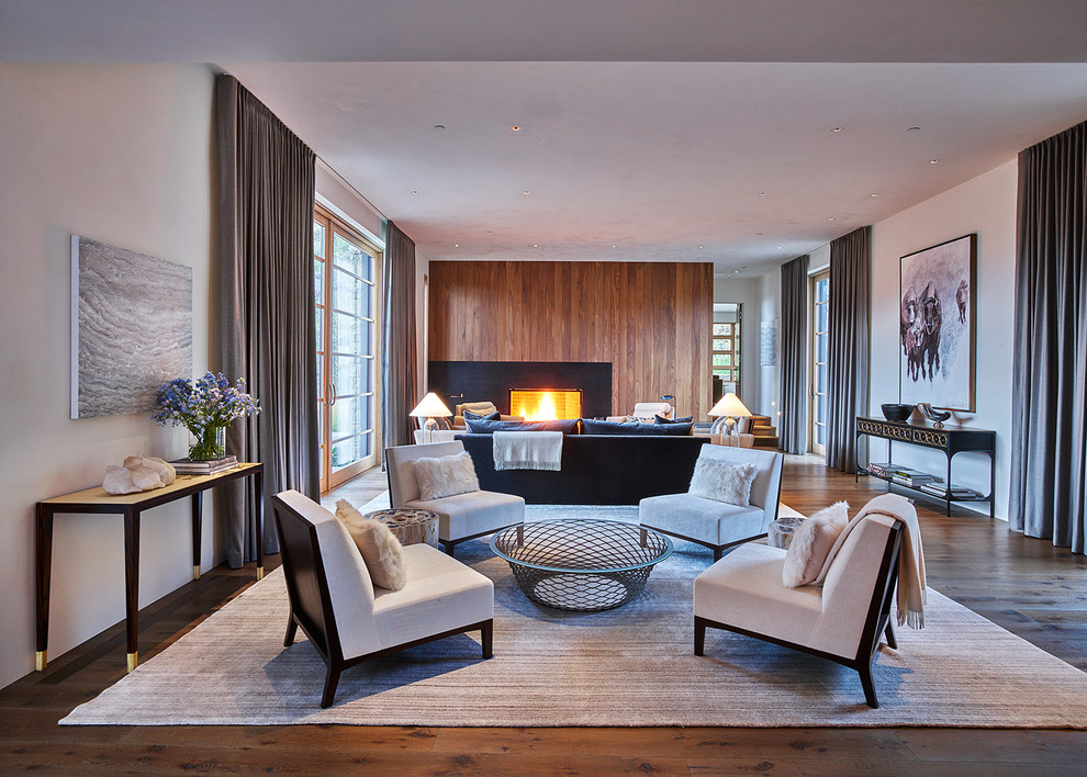 Idée de décoration pour un salon design ouvert avec une salle de réception, un mur blanc, un sol en bois brun et une cheminée standard.