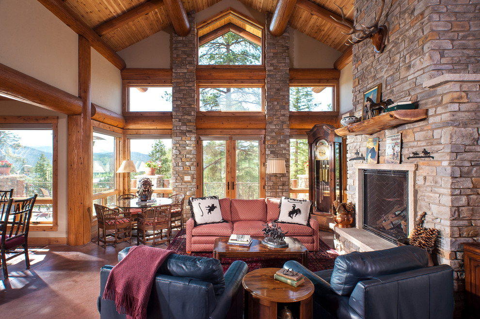 Inspiration for a medium sized rustic formal open plan living room in Denver with white walls, concrete flooring, a standard fireplace, a stone fireplace surround and a concealed tv.