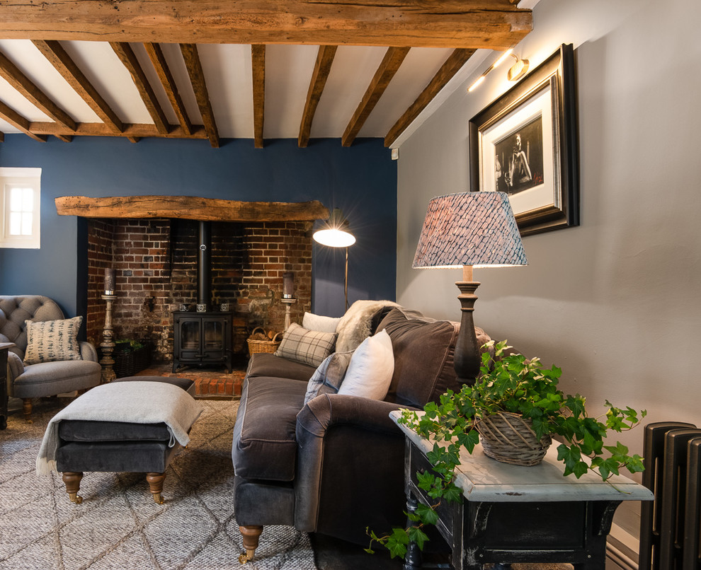 Exemple d'un salon nature de taille moyenne avec un mur gris, un sol en ardoise, un poêle à bois, un manteau de cheminée en brique et un sol gris.
