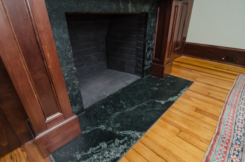 Example of a small classic enclosed light wood floor living room design in DC Metro with gray walls, a standard fireplace, a stone fireplace and a wall-mounted tv