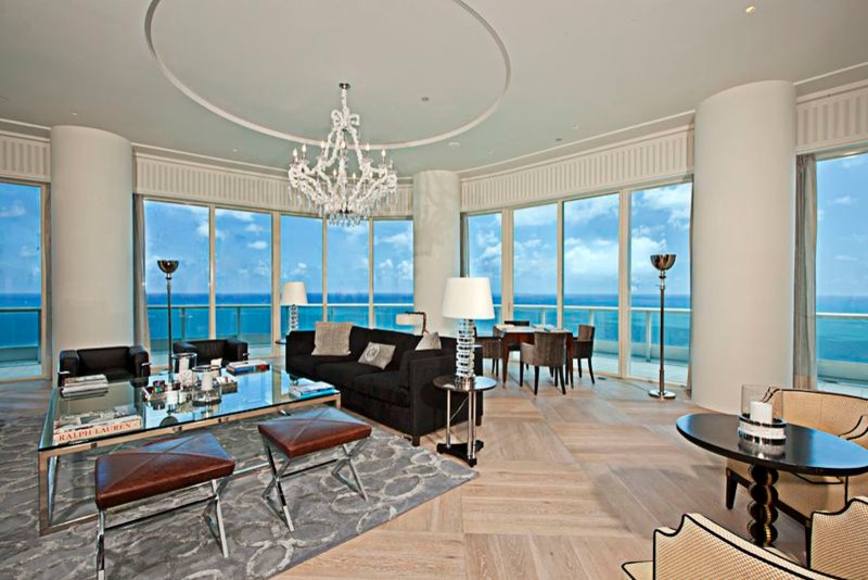 Huge trendy open concept light wood floor and beige floor living room photo in Miami with white walls