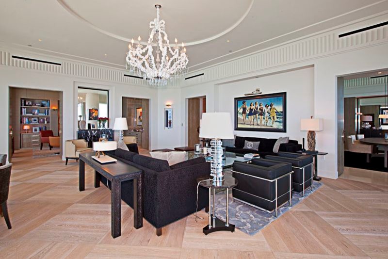 Aménagement d'un très grand salon contemporain ouvert avec un mur blanc, parquet clair et un sol beige.