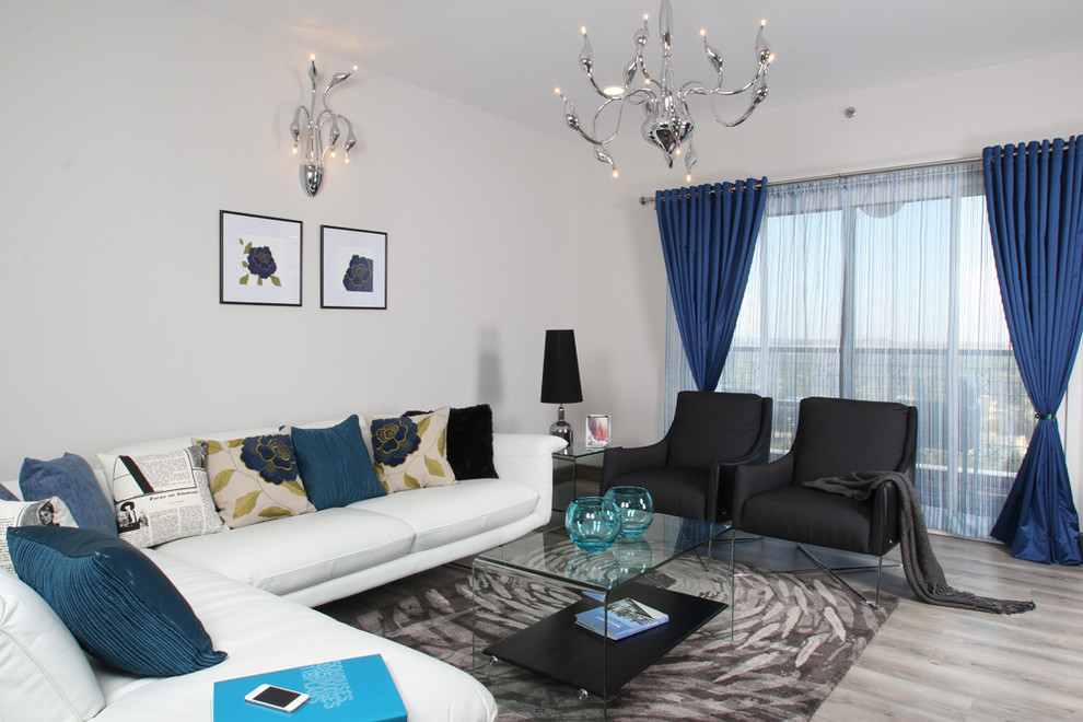 На фото: гостиная комната в современном стиле с белыми стенами и синими шторами