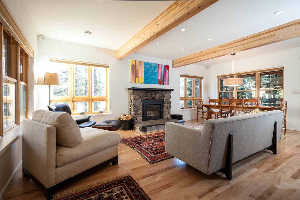 Mountain style open concept medium tone wood floor living room photo in San Francisco with white walls, a standard fireplace, a stone fireplace and no tv