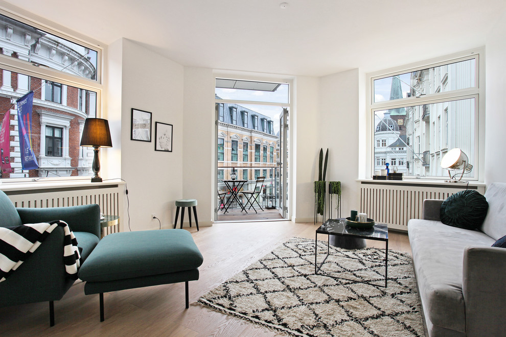 Mittelgroßes, Fernseherloses, Abgetrenntes Nordisches Wohnzimmer mit weißer Wandfarbe, hellem Holzboden und beigem Boden in Aarhus