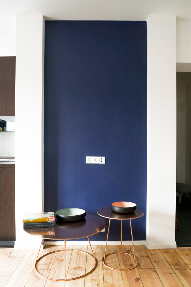 Bild på ett litet minimalistiskt separat vardagsrum, med blå väggar, mellanmörkt trägolv och en väggmonterad TV