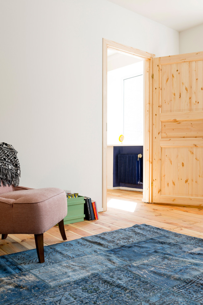 Esempio di un piccolo soggiorno nordico chiuso con pareti blu, pavimento in legno massello medio, nessun camino e TV a parete