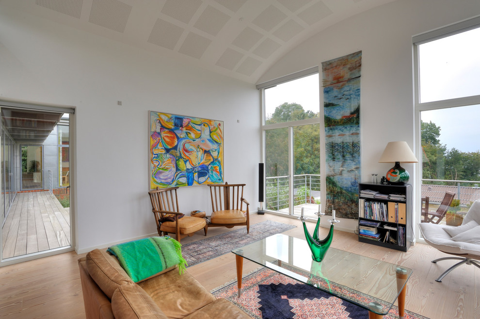 Foto de salón para visitas abierto bohemio de tamaño medio con paredes blancas y suelo de madera clara