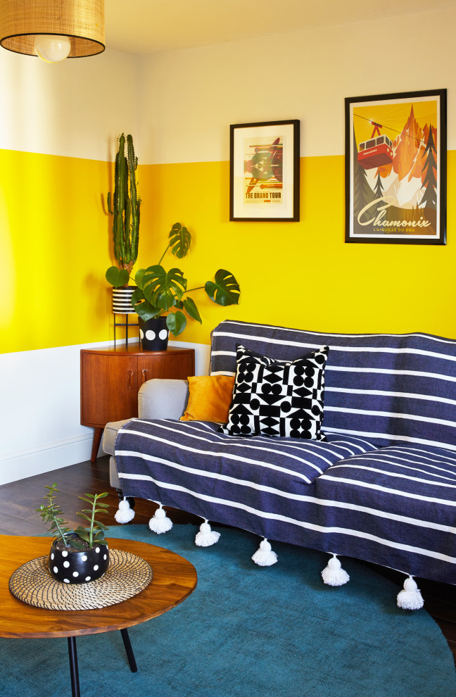 Immagine di un soggiorno bohémian di medie dimensioni e chiuso con pareti gialle, parquet scuro, nessun camino e TV autoportante