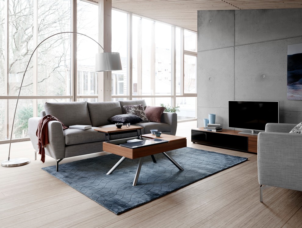Idee per un grande soggiorno minimalista aperto con pavimento beige, sala formale, pareti grigie, parquet chiaro, nessun camino e TV autoportante