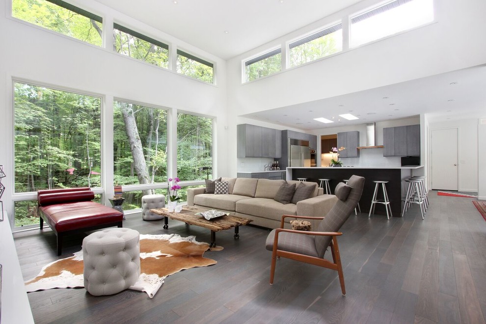 This is an example of a large contemporary open plan living room in Chicago with white walls, dark hardwood flooring and no tv.