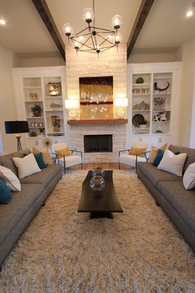 Repräsentatives, Fernseherloses Klassisches Wohnzimmer mit beiger Wandfarbe, hellem Holzboden, Kamin und Kaminumrandung aus Stein in Austin