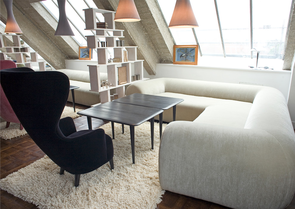 Cette image montre un grand salon mansardé ou avec mezzanine design avec un sol en bois brun.