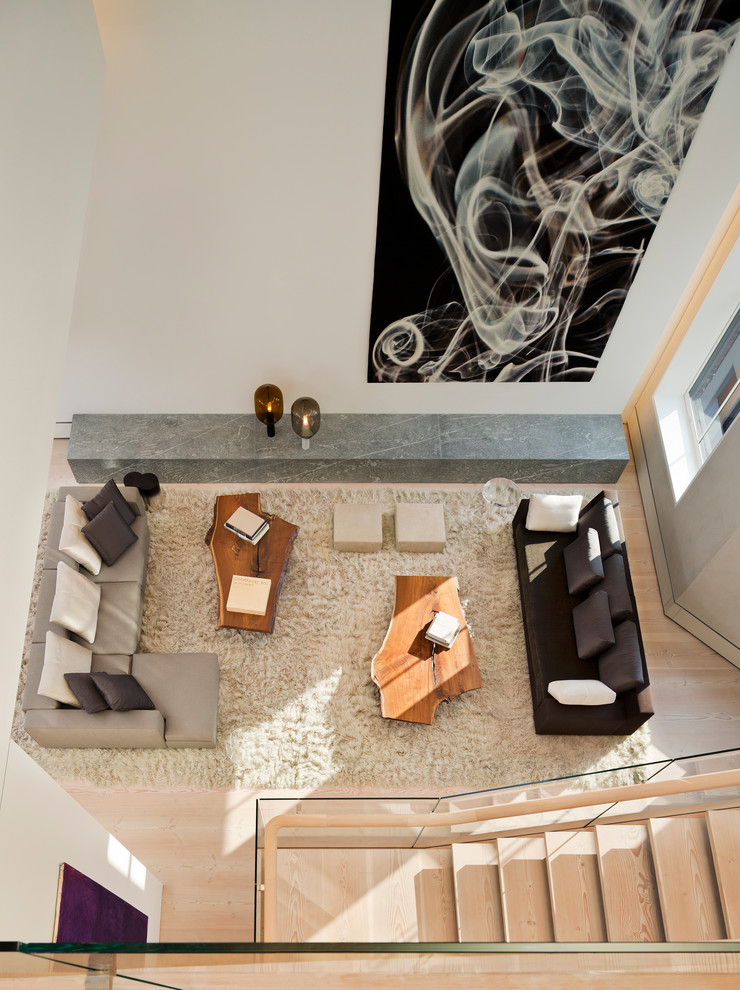 Geräumiges, Offenes Modernes Wohnzimmer mit beiger Wandfarbe, hellem Holzboden und verputzter Kaminumrandung in New York