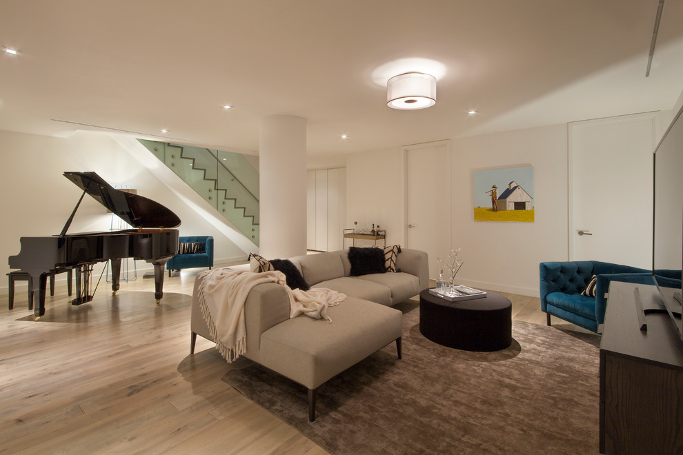 Immagine di un grande soggiorno design chiuso con sala formale, pareti bianche, parquet chiaro e TV autoportante