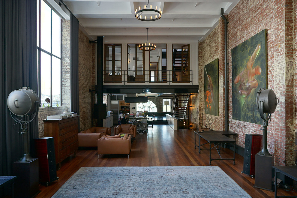 Living room - large industrial open concept dark wood floor living room idea in New York with a wall-mounted tv