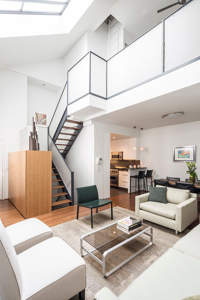 Offenes Modernes Wohnzimmer mit weißer Wandfarbe und braunem Holzboden in New York