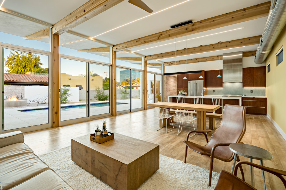 Ispirazione per un soggiorno design aperto con pareti gialle, pavimento in legno massello medio e pavimento marrone