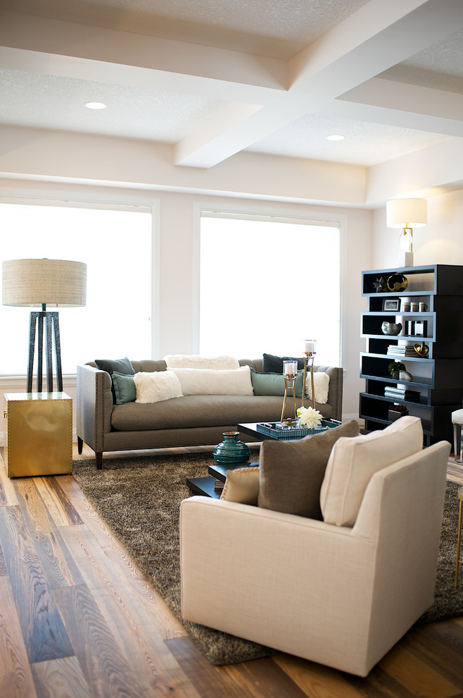 This is an example of a medium sized contemporary open plan living room in Edmonton with medium hardwood flooring, pink walls, no fireplace and no tv.