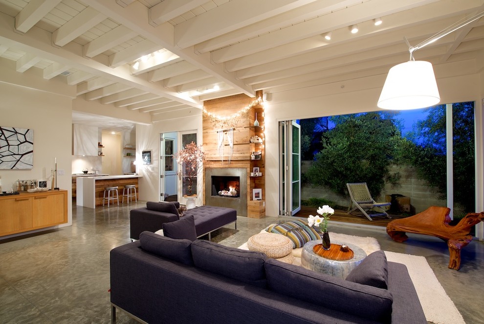 На фото: парадная, открытая гостиная комната в морском стиле с бежевыми стенами, бетонным полом и стандартным камином