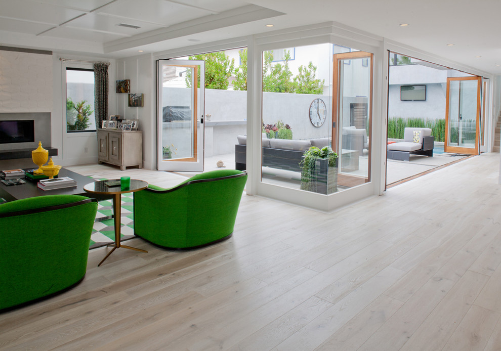 Großes, Offenes Modernes Wohnzimmer mit weißer Wandfarbe, hellem Holzboden, Gaskamin und Kaminumrandung aus Metall in Orange County