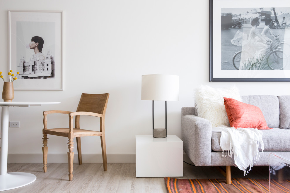 Diseño de salón abierto nórdico de tamaño medio con paredes blancas y suelo de madera clara