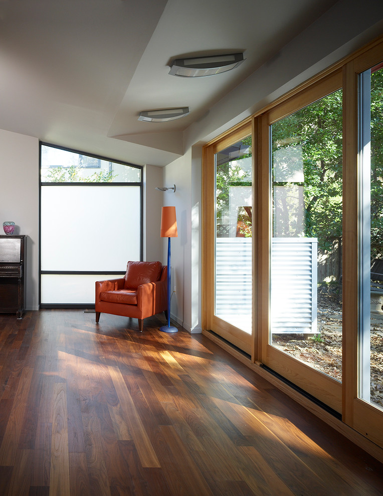 Diseño de salón minimalista con paredes blancas y suelo marrón