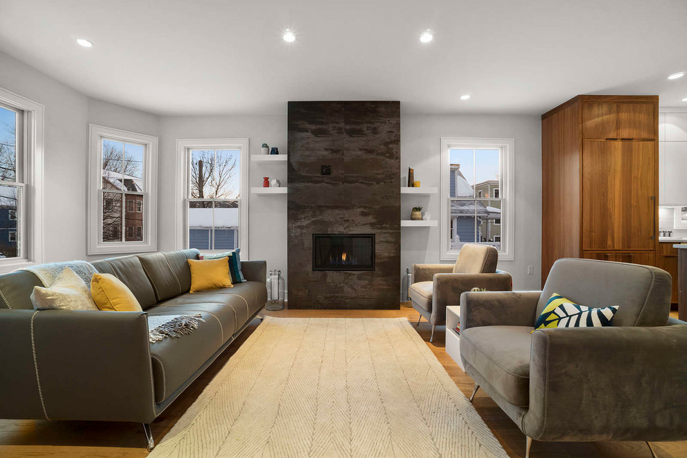 Idee per un grande soggiorno moderno stile loft con pavimento in legno massello medio, cornice del camino in pietra, TV a parete e pavimento marrone