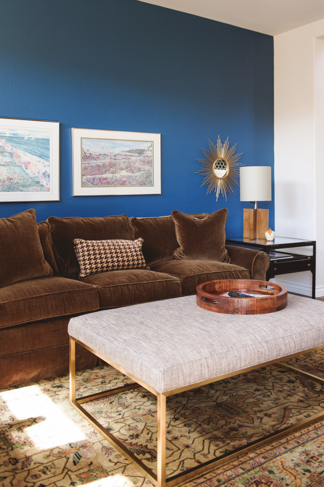 サンディエゴにあるお手頃価格の小さなおしゃれな独立型リビング (青い壁、ラミネートの床、標準型暖炉、積石の暖炉まわり、壁掛け型テレビ、茶色い床) の写真