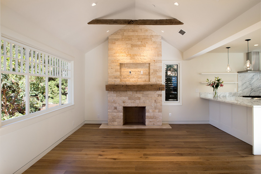 Idée de décoration pour un salon minimaliste ouvert avec un mur blanc, un sol en bois brun, une cheminée standard et un manteau de cheminée en pierre.