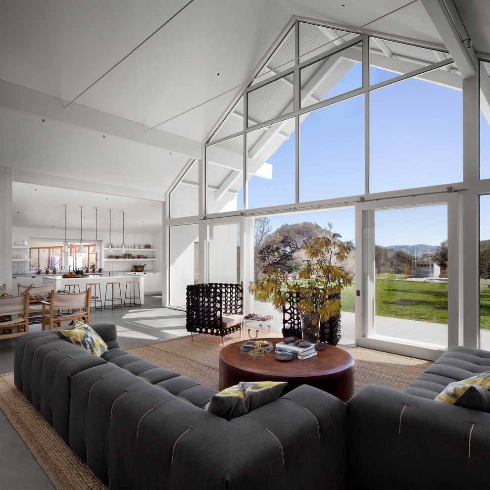 This is an example of a rural open plan living room in San Francisco with white walls and concrete flooring.