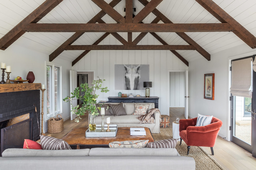 Example of a farmhouse formal light wood floor and beige floor living room design in San Francisco with white walls, a standard fireplace and a brick fireplace