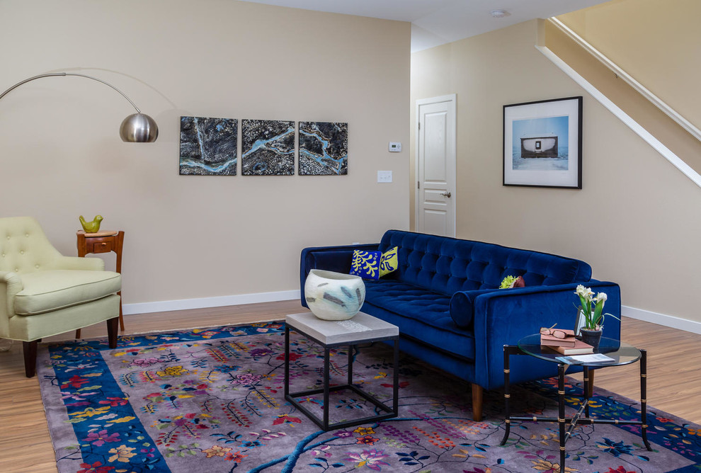 На фото: изолированная гостиная комната среднего размера в стиле фьюжн с бежевыми стенами, полом из винила, стандартным камином, фасадом камина из плитки и коричневым полом