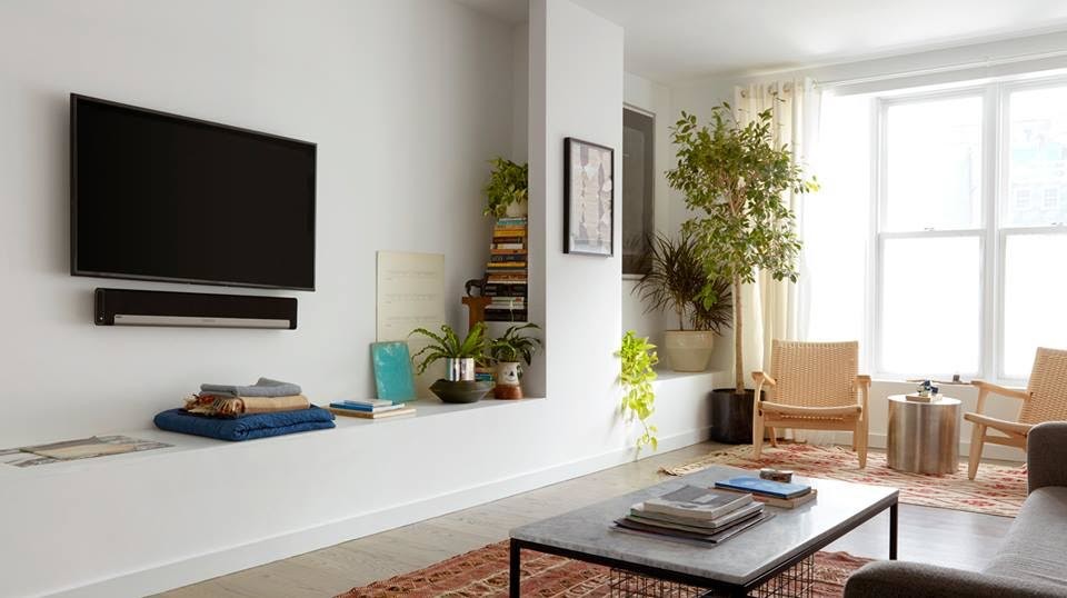 Foto på ett mellanstort funkis vardagsrum, med vita väggar, en väggmonterad TV, ljust trägolv och grått golv