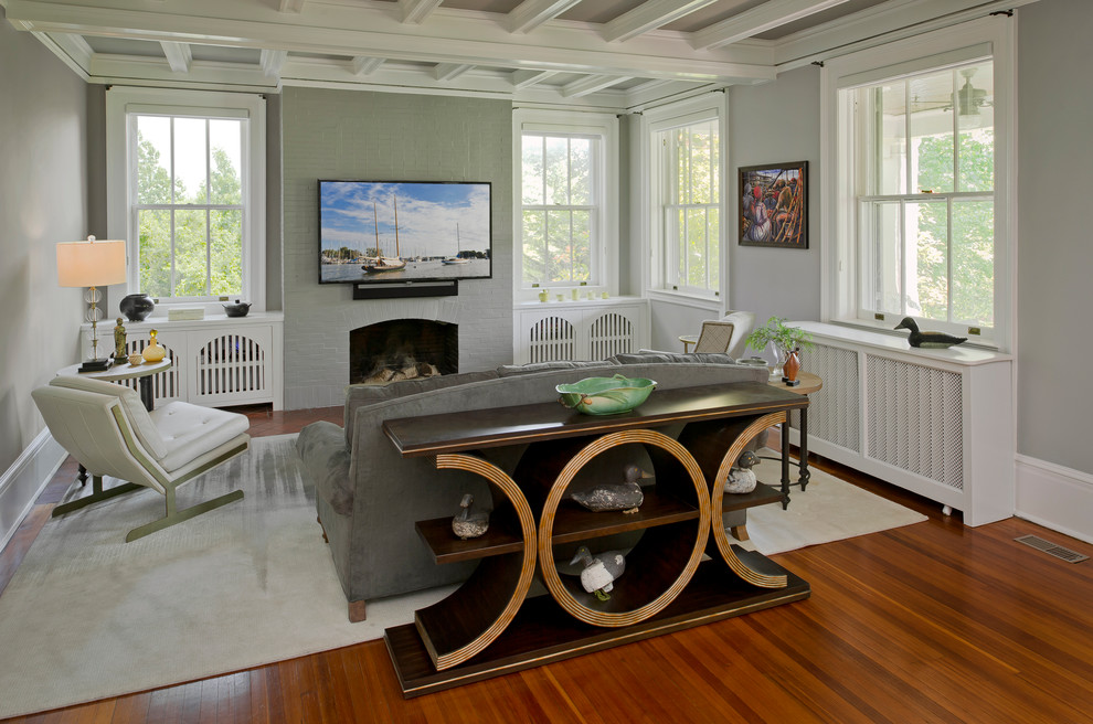 Offenes Klassisches Wohnzimmer mit grauer Wandfarbe, dunklem Holzboden, Kamin, TV-Wand, braunem Boden und Kaminumrandung aus Backstein in Baltimore