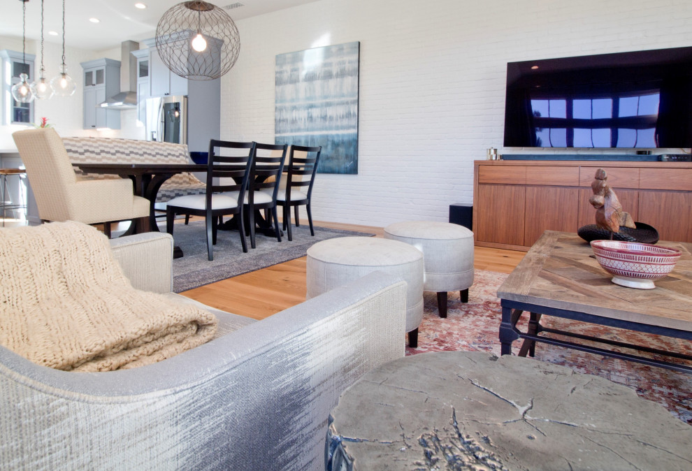 Foto de salón tipo loft clásico renovado de tamaño medio sin chimenea con paredes grises, suelo de madera clara, televisor independiente y ladrillo