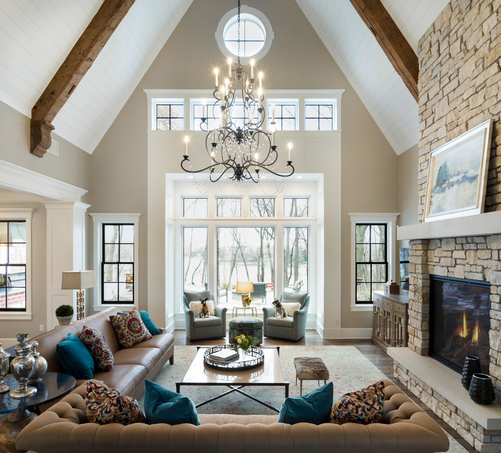 Offenes Klassisches Wohnzimmer mit beiger Wandfarbe, dunklem Holzboden, Kamin und Kaminumrandung aus Stein in Minneapolis