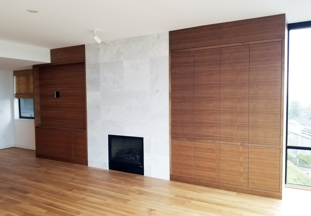 Cette photo montre un salon tendance en bois de taille moyenne et ouvert avec un mur blanc, parquet clair, une cheminée standard, un manteau de cheminée en pierre, un téléviseur encastré et un sol beige.