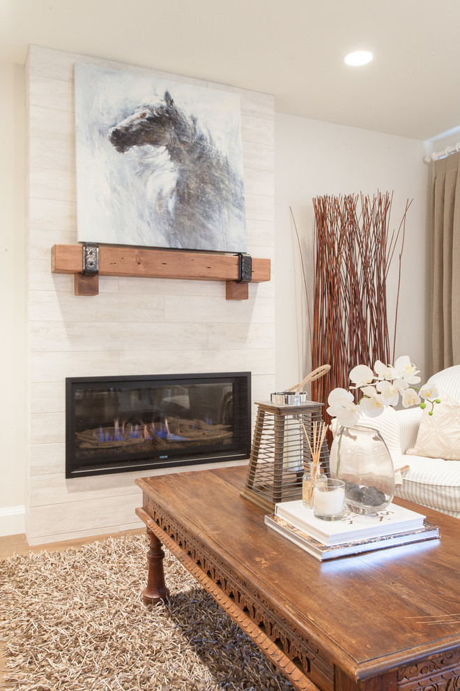 Aménagement d'un petit salon romantique ouvert avec un mur blanc, un sol en bois brun, une cheminée standard, un manteau de cheminée en carrelage et aucun téléviseur.