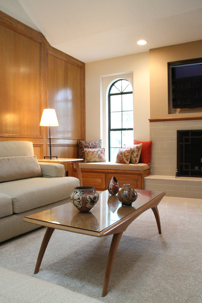 Inredning av ett klassiskt mellanstort vardagsrum, med en väggmonterad TV, vita väggar, heltäckningsmatta, en standard öppen spis och en spiselkrans i trä