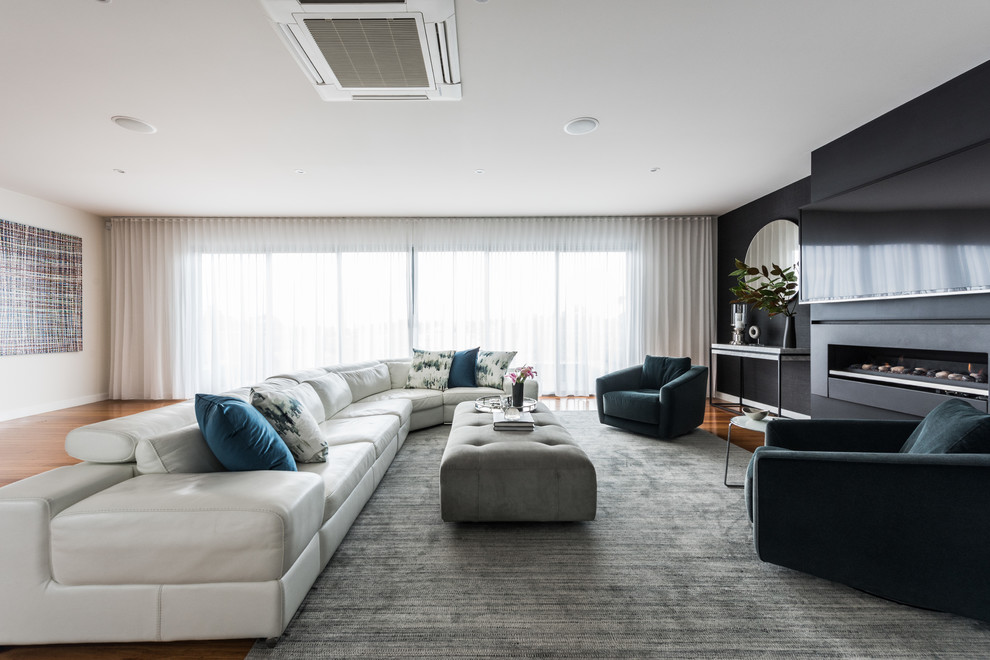 Immagine di un soggiorno contemporaneo chiuso con pareti beige, pavimento in legno massello medio, camino lineare Ribbon, TV a parete e pavimento marrone
