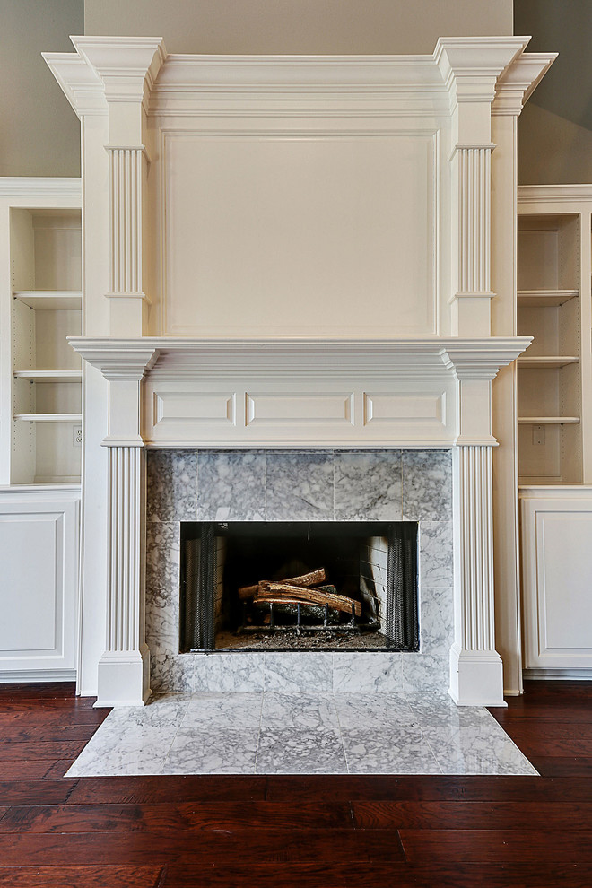 Example of a mid-sized classic open concept dark wood floor living room design in New Orleans with white walls, a standard fireplace, a stone fireplace and a media wall