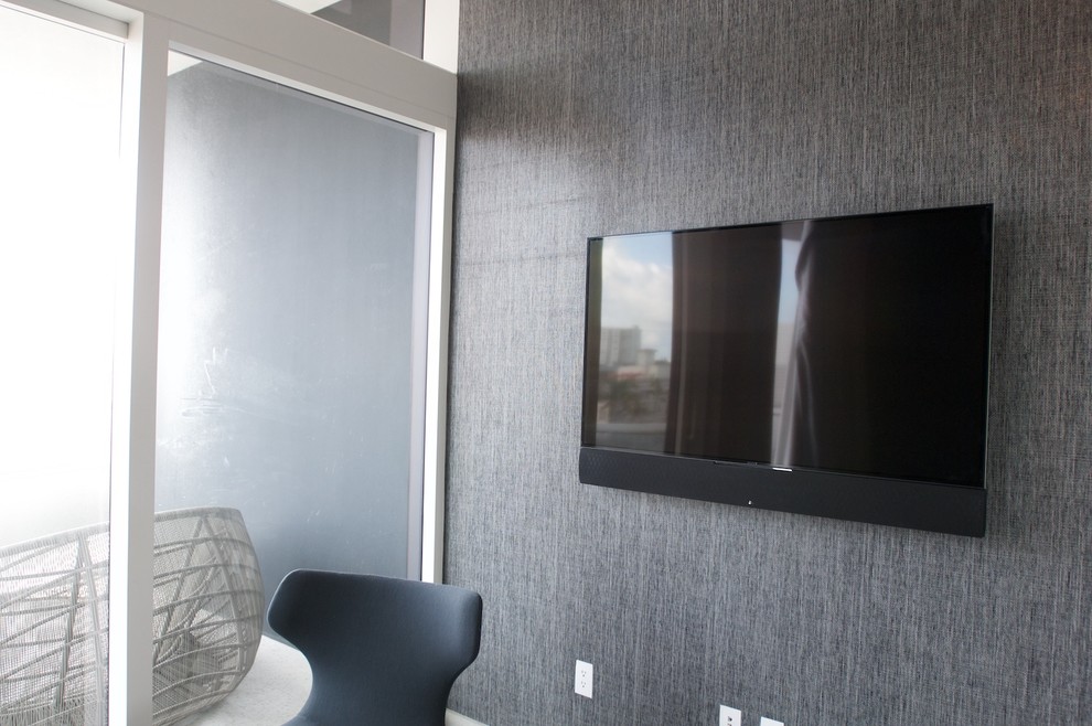 Foto de salón para visitas abierto minimalista de tamaño medio con paredes grises y televisor colgado en la pared