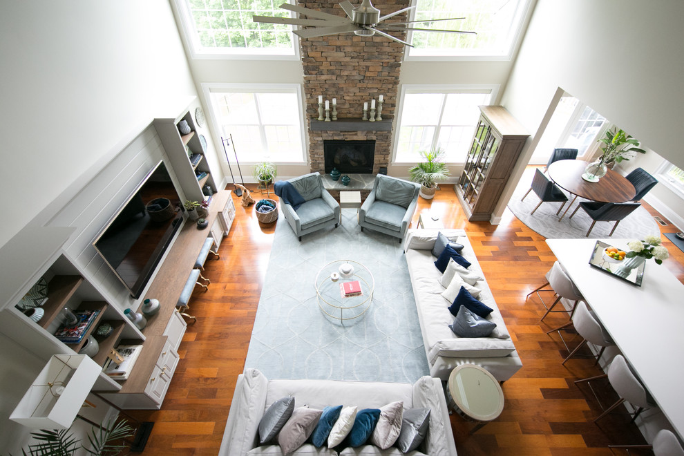 Großes, Offenes Modernes Wohnzimmer mit beiger Wandfarbe, braunem Holzboden, Kamin, Kaminumrandung aus Stein, Multimediawand und braunem Boden in Raleigh