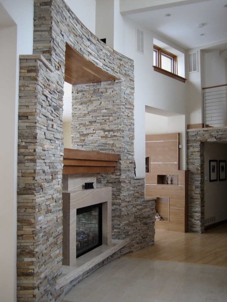 This is an example of a large modern formal open plan living room in Denver with white walls, light hardwood flooring, a two-sided fireplace and a stone fireplace surround.